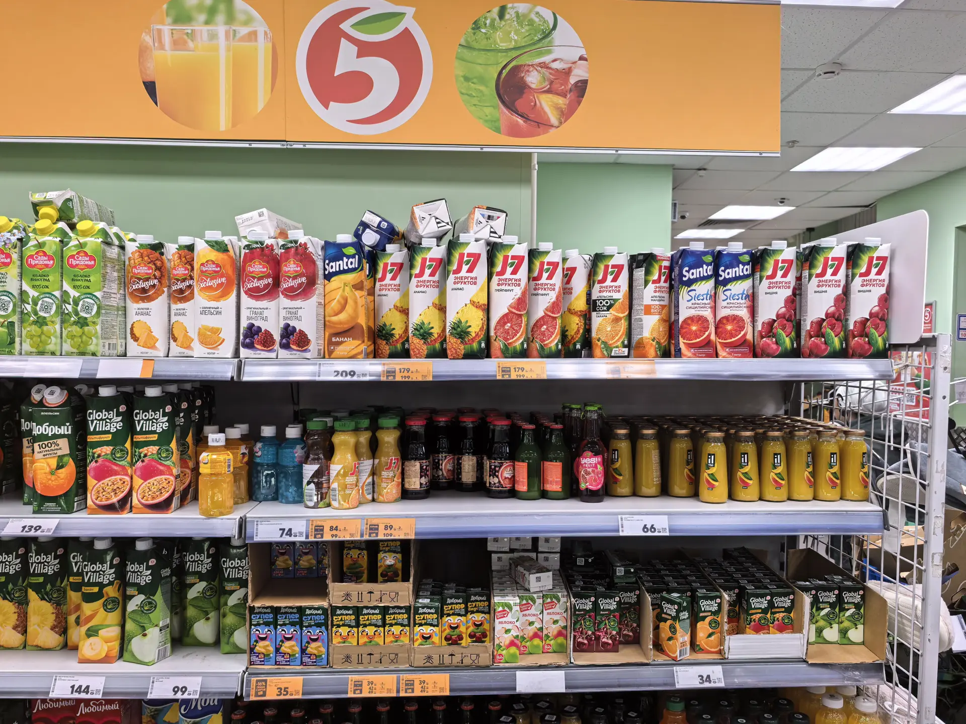 Полка в магазине с бутылками и пакетами соков, снятая на Pura 80 Pro